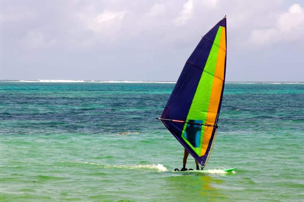 Man windsurfing on calm ocean waters